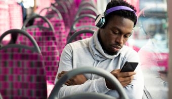 Image of man with headphones looking at phone